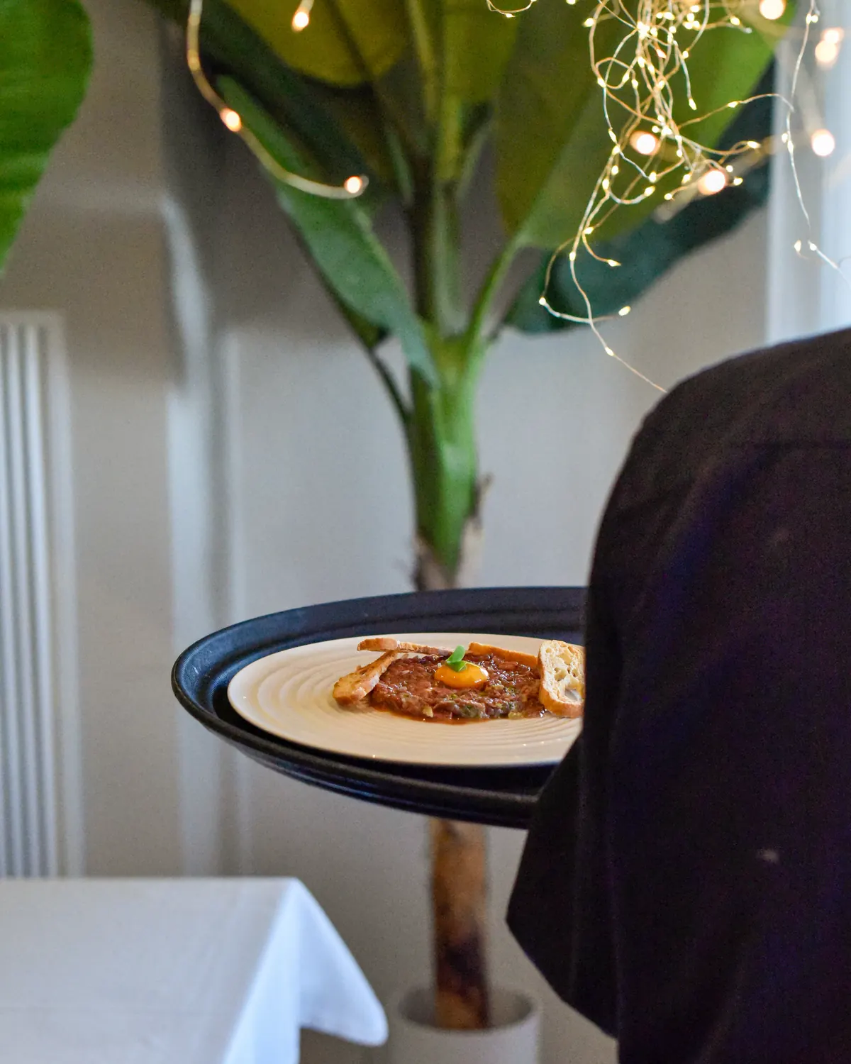 Camarero llevando un plato recién emplatado